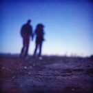 Romantic couple walking holding hands on beach in blue Medium format color negative film photo by edwardolive