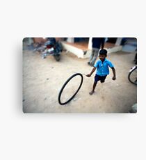 Boy playing with tyre Canvas Print
