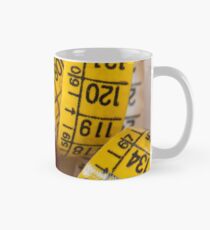 Doll resting on measuring tape Mug