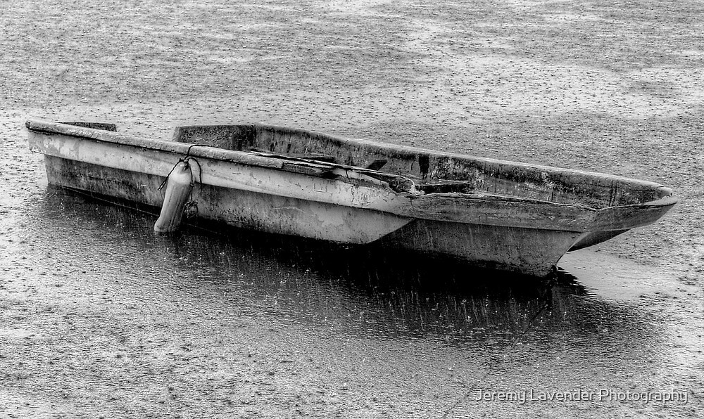 "Small boat under a heavy rain in Nassau Harbour, The Bahamas" by