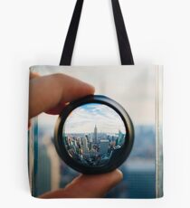 Man holding a lens over Manhattan Tote Bag