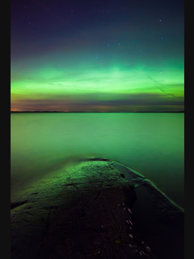 Northern lights glow over lake by Juhku