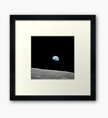 Earth rising above the lunar horizon. Framed Print