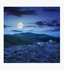 light on stone mountain slope with forest at night Photographic Print
