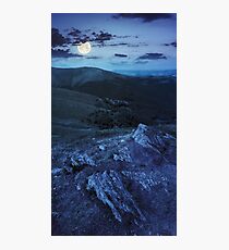 light on stone mountain slope with forest at night Photographic Print