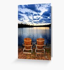 Wooden chairs at sunset on lake shore Greeting Card