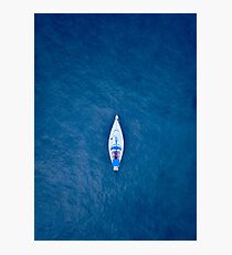 A drone shot of a sailing boat surrounded by deep blue sea water Photographic Print