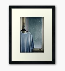 Hanging T-shirt and broken window pane Framed Print