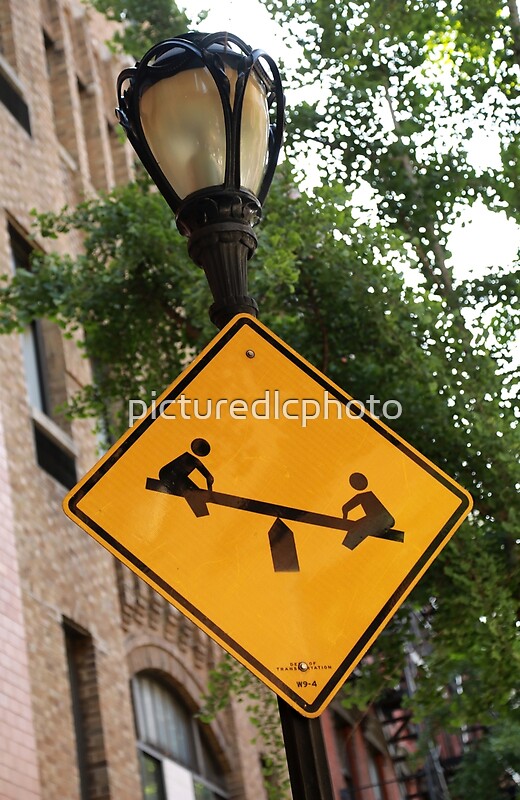 "Kids at play. See saw. Teeter totter. Street sign." by picturedlcphoto